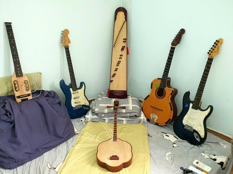 Đàn guitar và đàn tranh được sắp xếp trên giường trong phòng ngủ